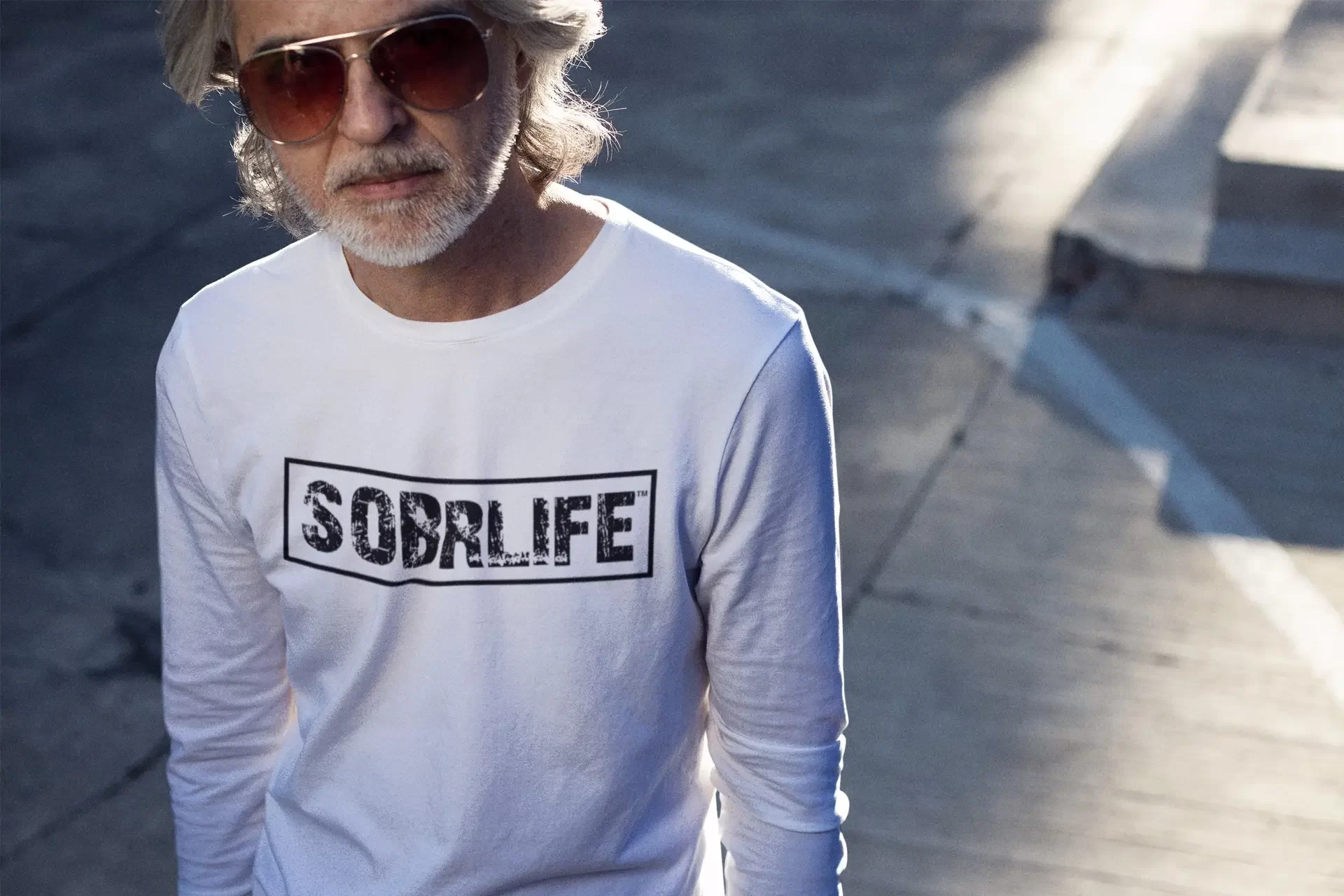 A man wearing the classic SOBRLIFE white long sleeve tee