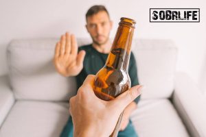 Can a recovering alcoholic drink again concept pic shows a man refusing a beer