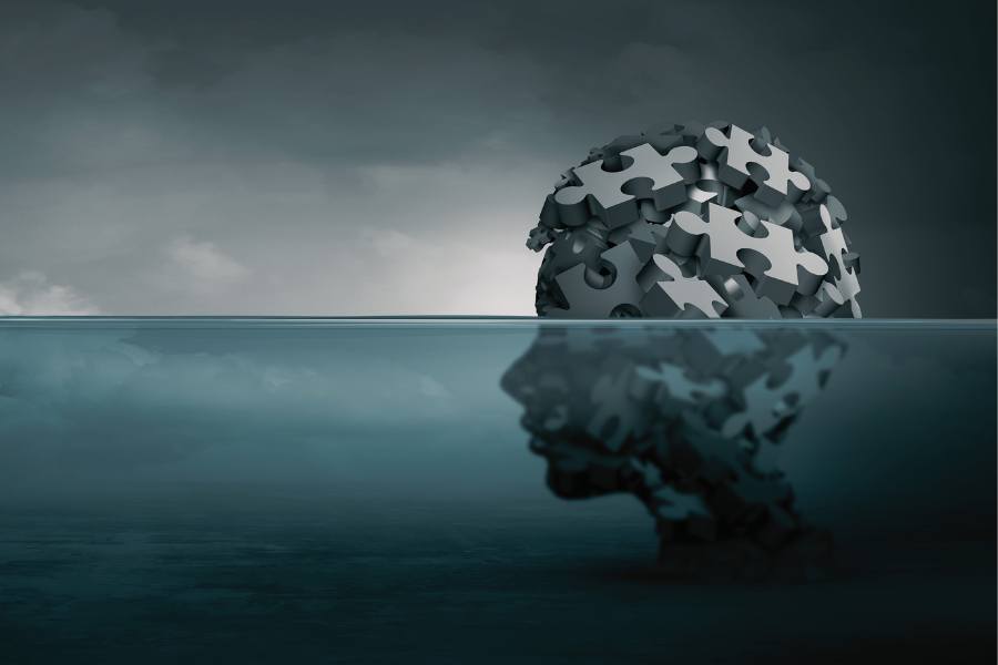 A silhouette of a person with puzzle pieces as their brain