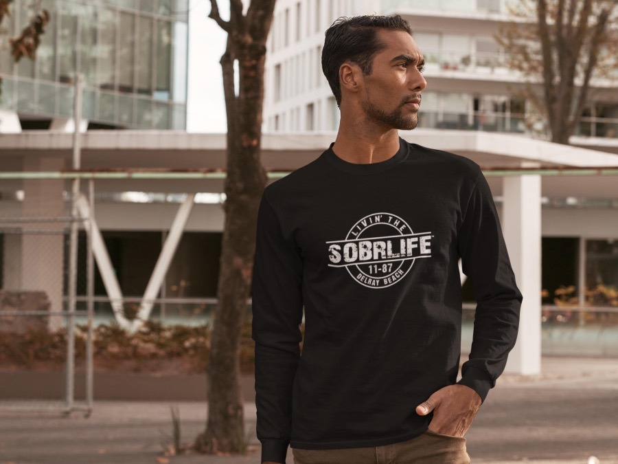 A man wears the SOBRLIFE Celebrations long sleeve tee in black