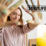 An artist shows her painted hands in a SOBRLIFE blog on art therapy for addiction recovery