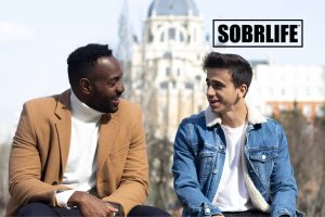 Two men talk on a bench to show the concept of how to become a sober companion