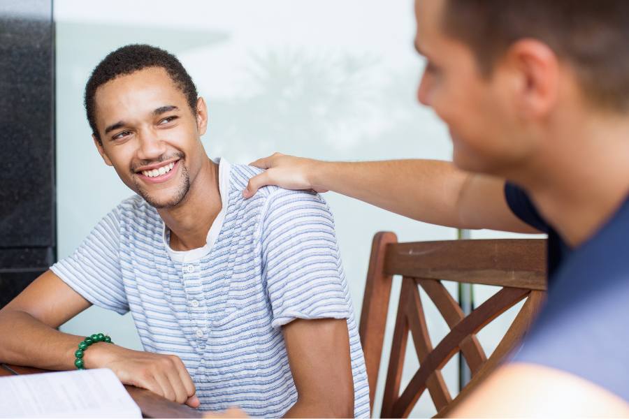 A male sober companion gives advice to his college age client in recovery