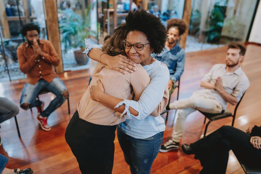 Peer support at RCOs concept pic shows women hugging during group meeting