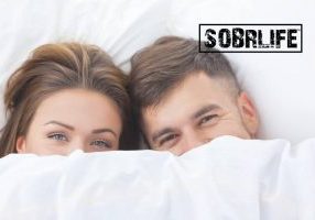 AA sex inventory concept pic from SOBRLIFE shows couple in bed with sheets pulled up to their eyes