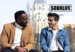 Two men talk on a bench to show the concept of how to become a sober companion