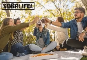 Four friends enjoy a picnic and pizza to show the concept of making friends sober